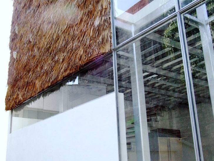 Частично пушистый стеклянный куб с соломенными крышами на фасаде