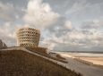 Климат-устойчивая башня возвышается над искусственной дюной