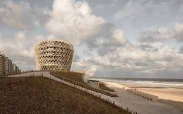Климат-устойчивая башня возвышается над искусственной дюной